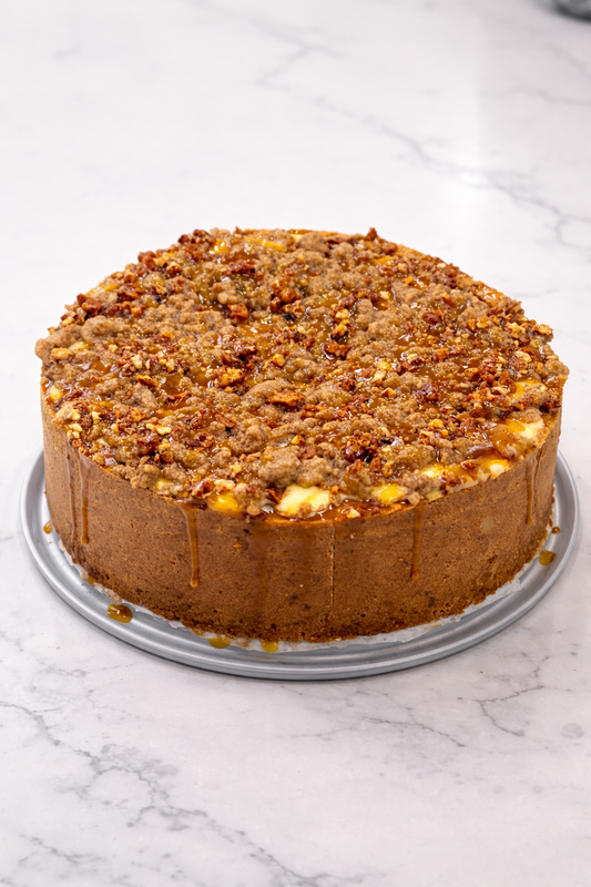 Round cake with a crumbly topping on a marble surface