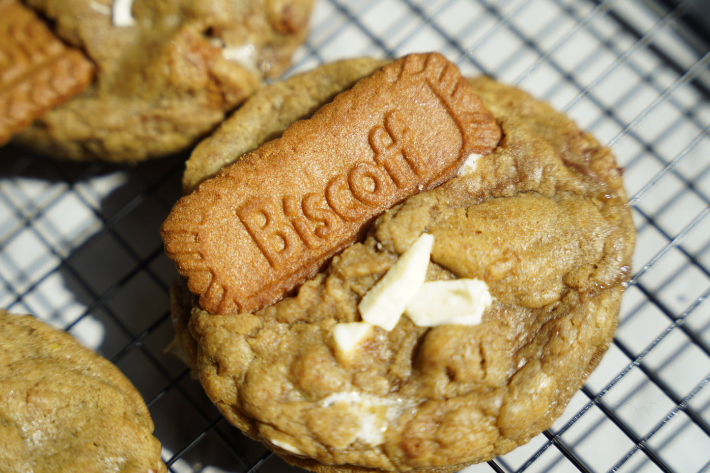 Cookie with a Biscoff biscuit on top on a cooling rack