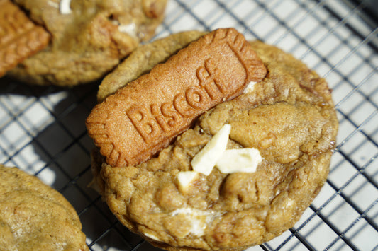 Cookie with a Biscoff biscuit on top on a cooling rack