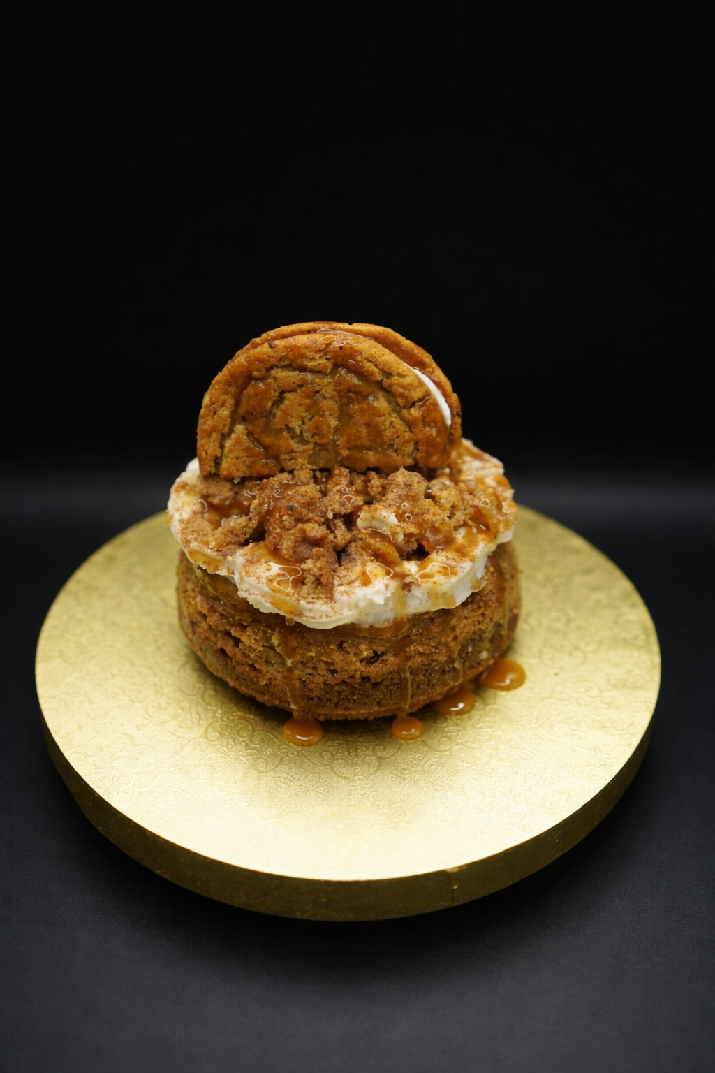 Two-layered cookie dessert on a gold plate with a black background
